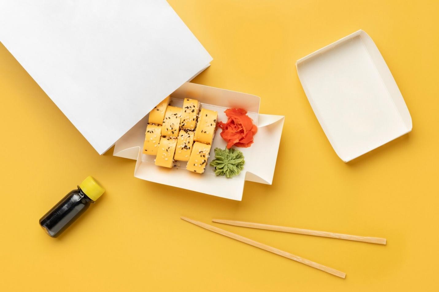 A box of sushi with chopsticks and a bottle of soy sauce

Description automatically generated