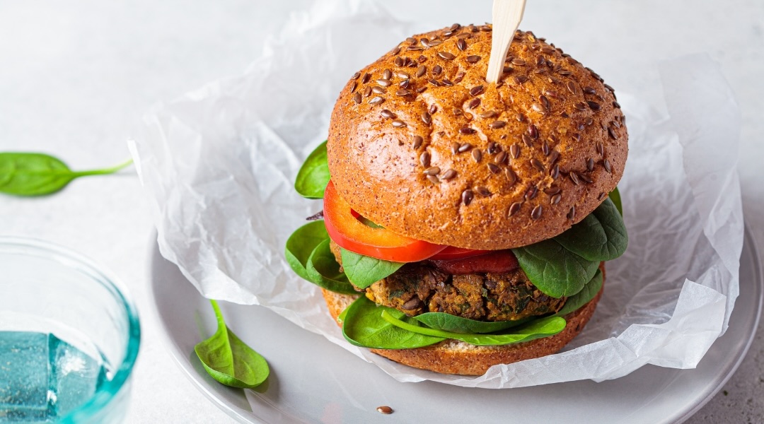 lentil burger with tomatoes and spinach in white paper