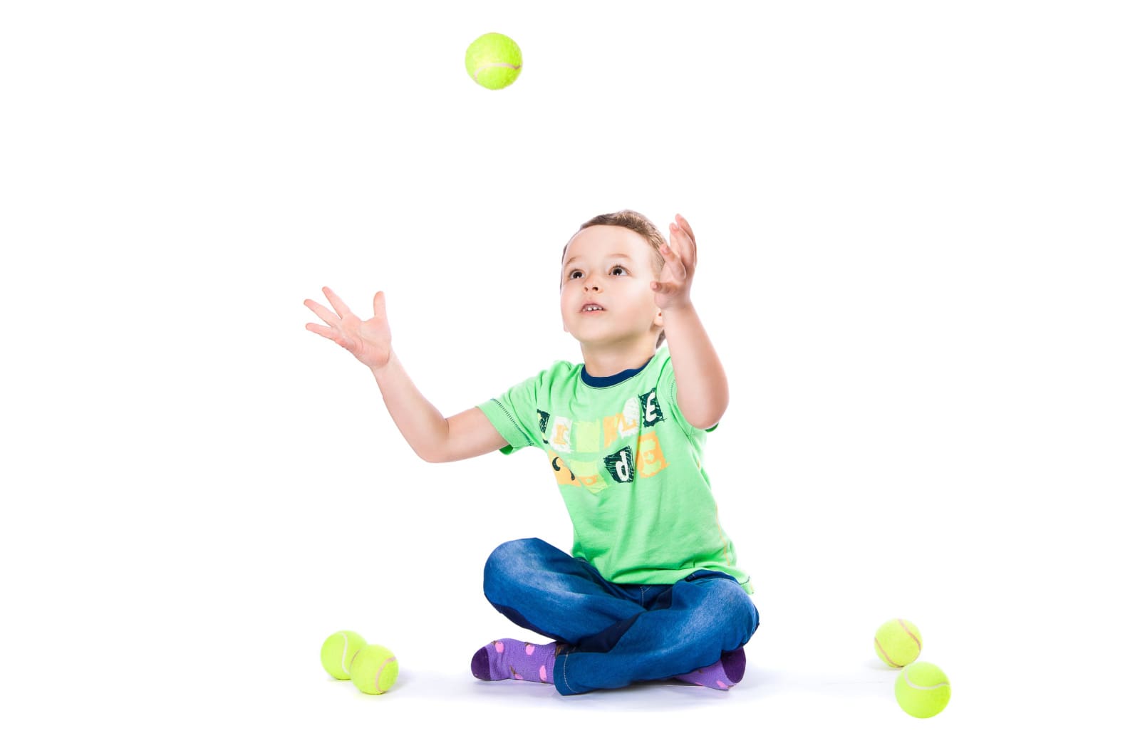 A young boy bouncing a tennis ball against the wall. Bouncing a ball against a wall can help strengthen visual skills in children