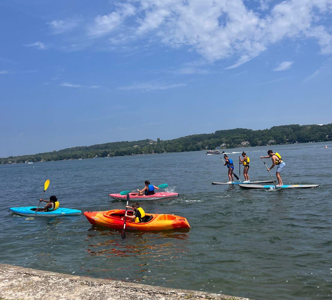Campers at an overnight sports camp enjoying water activities on the lake