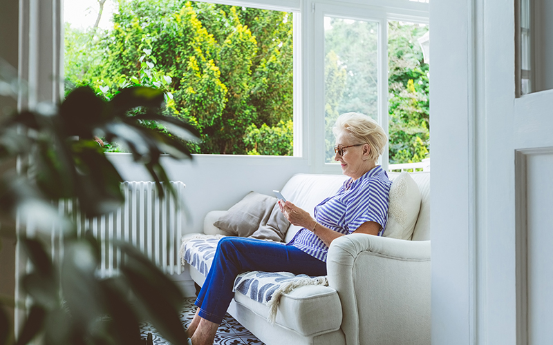 senior lady sitting on phone on couch