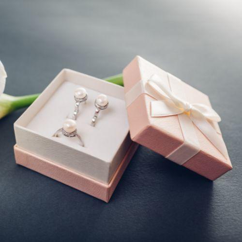 A box with earrings and a flower

Description automatically generated