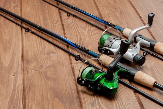 Fishing tackle - fishing spinning, hooks and lures on wooden background with copy space.