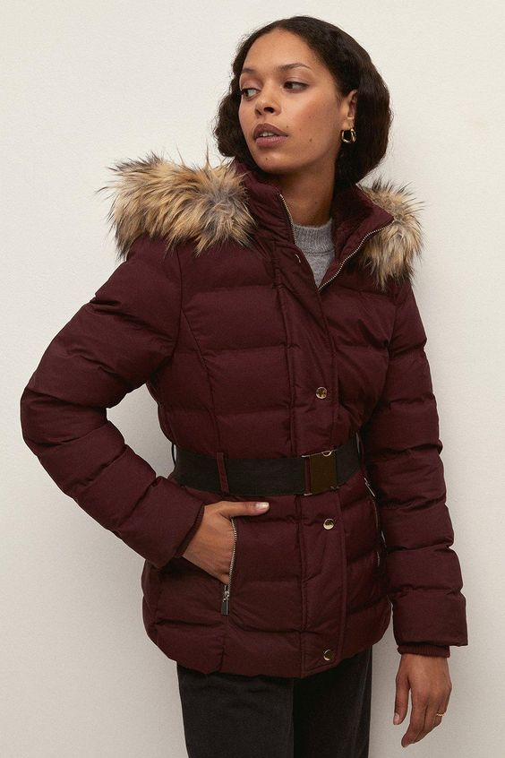 Picture of a model wearing the coat and accentuating her shape