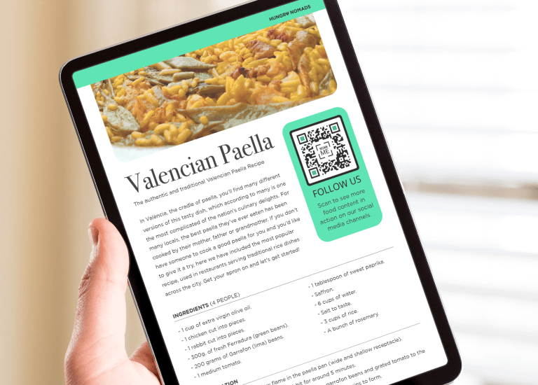 An person holiding an eBook in their hands and reading the Valencian Paella recipe.