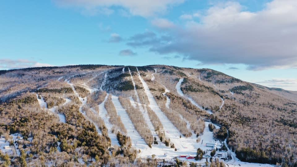 A ski slope with ski tracks Description automatically generated