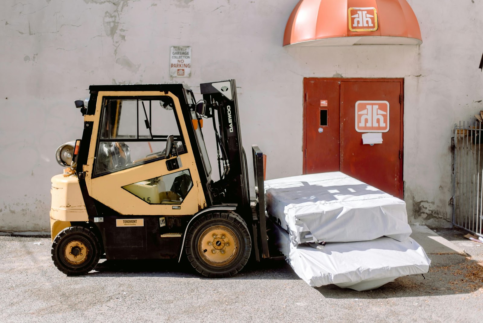 A yellow forklift lifting two large white boxes