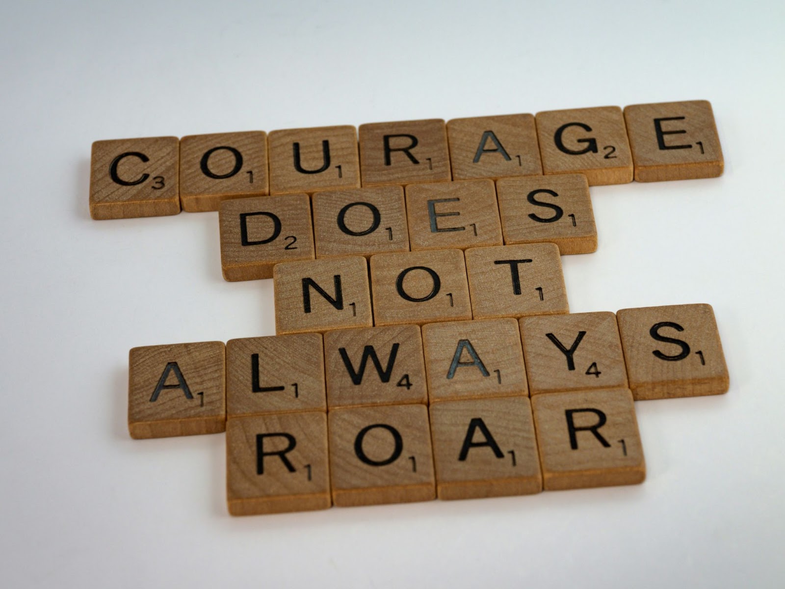 Scrabble tiles that says, "courage does not always roar. "