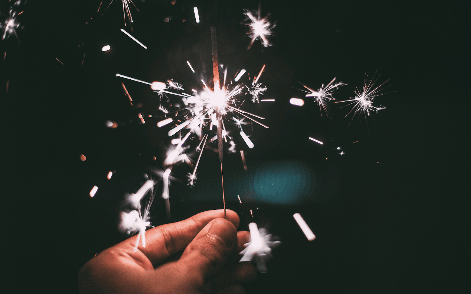 A hand holding a sparklerDescription automatically generated