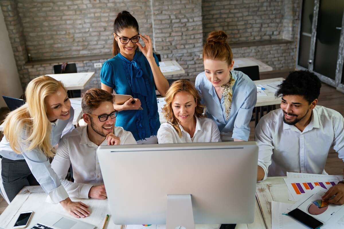 Group of employees looking at a computer