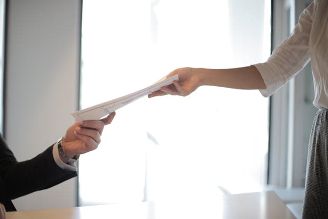 1 person handling over document to the other one