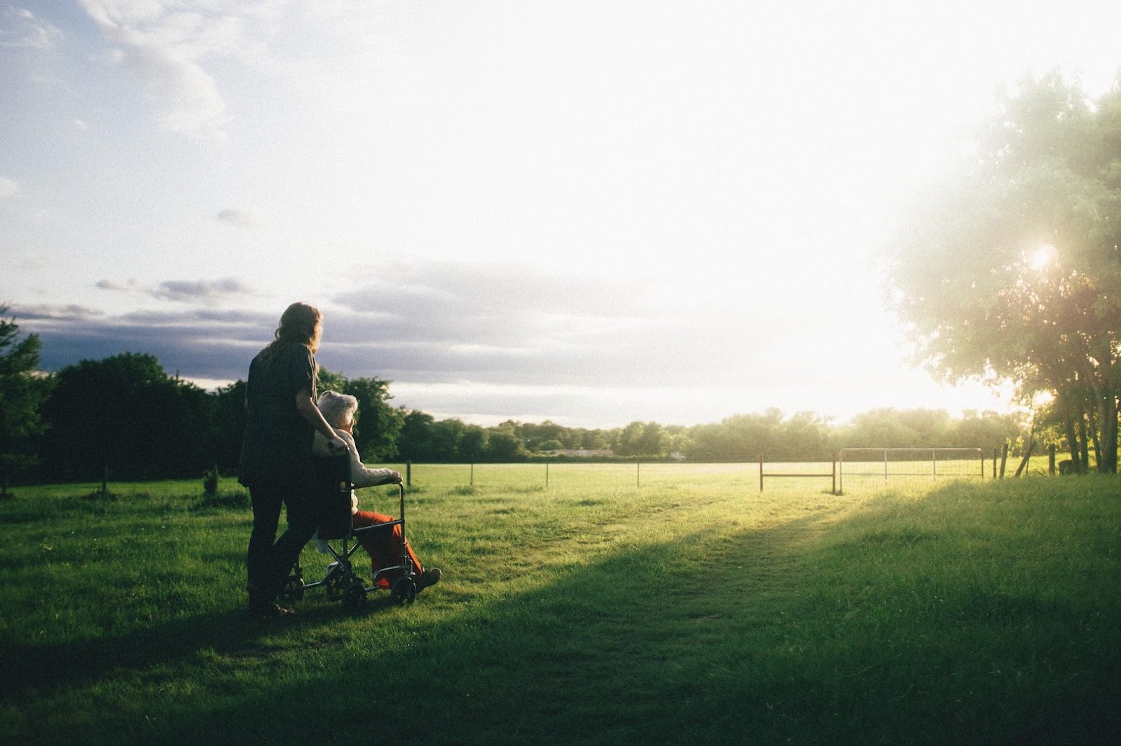 elderly woman and caregiver in a field