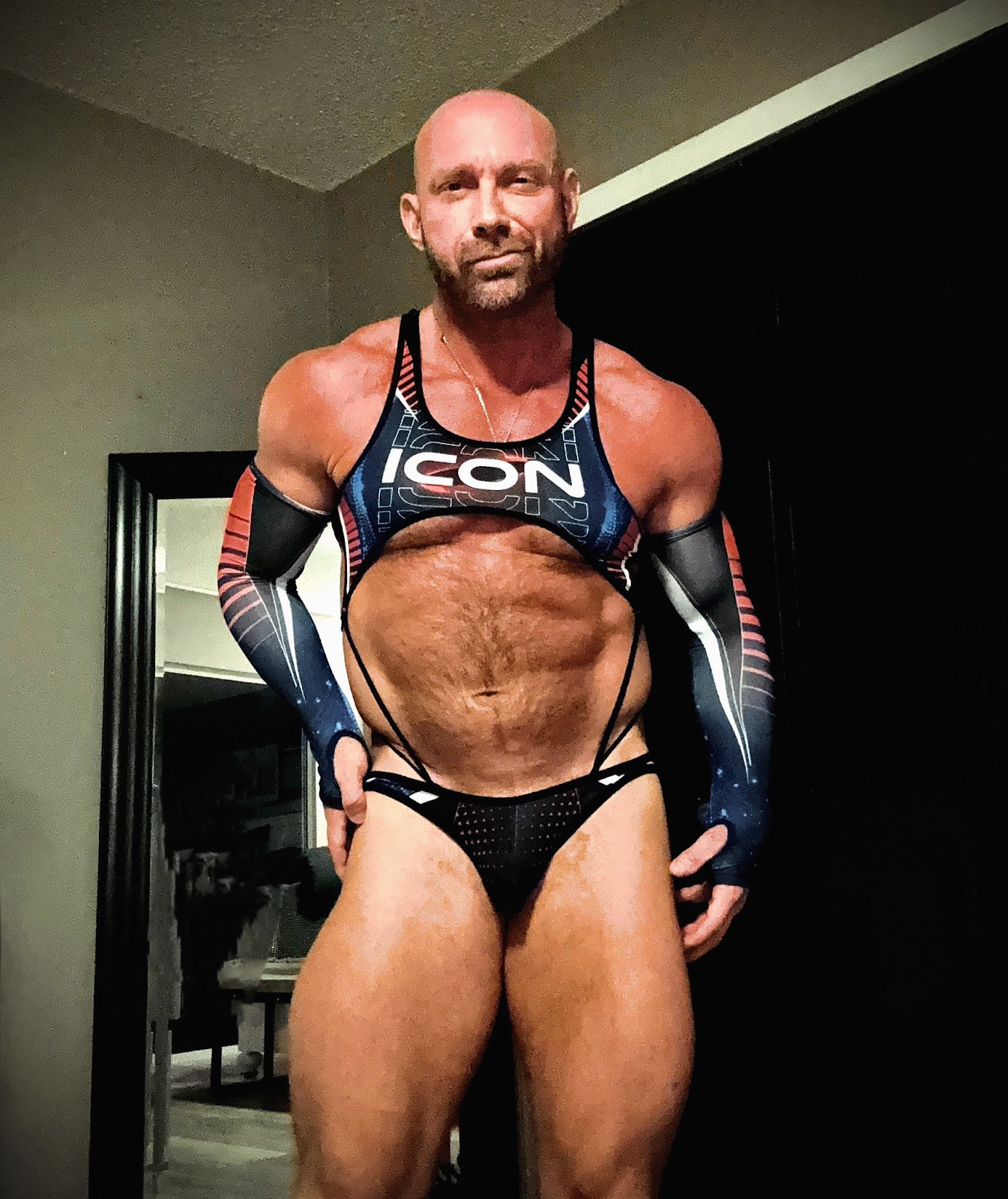 Killian Knox wearing skin tight fetish gear and panties with the words icon on his crop top taking selfies