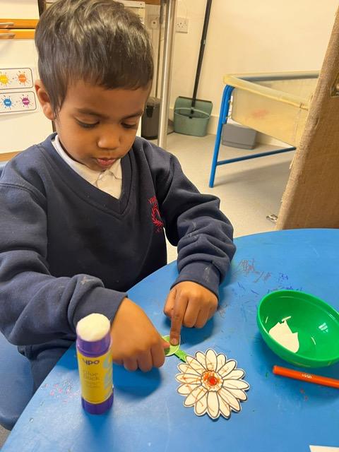 A child painting a flower on a table

Description automatically generated