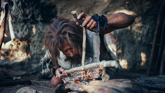 Closeup Shot Of A Primeval Caveman Wearing Animal Skin Trying To Make ...