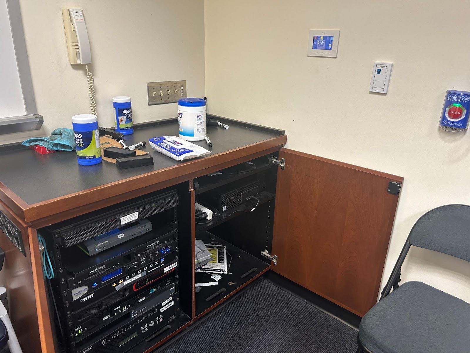 View of the AV cabinet where the computer is located. Also seen: Hotline phone and touch control panel.