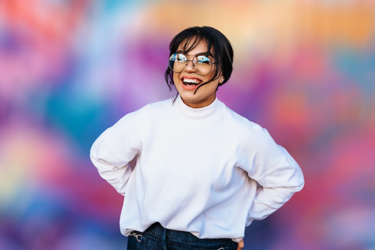 A lady standing in front of a colorful blurred background