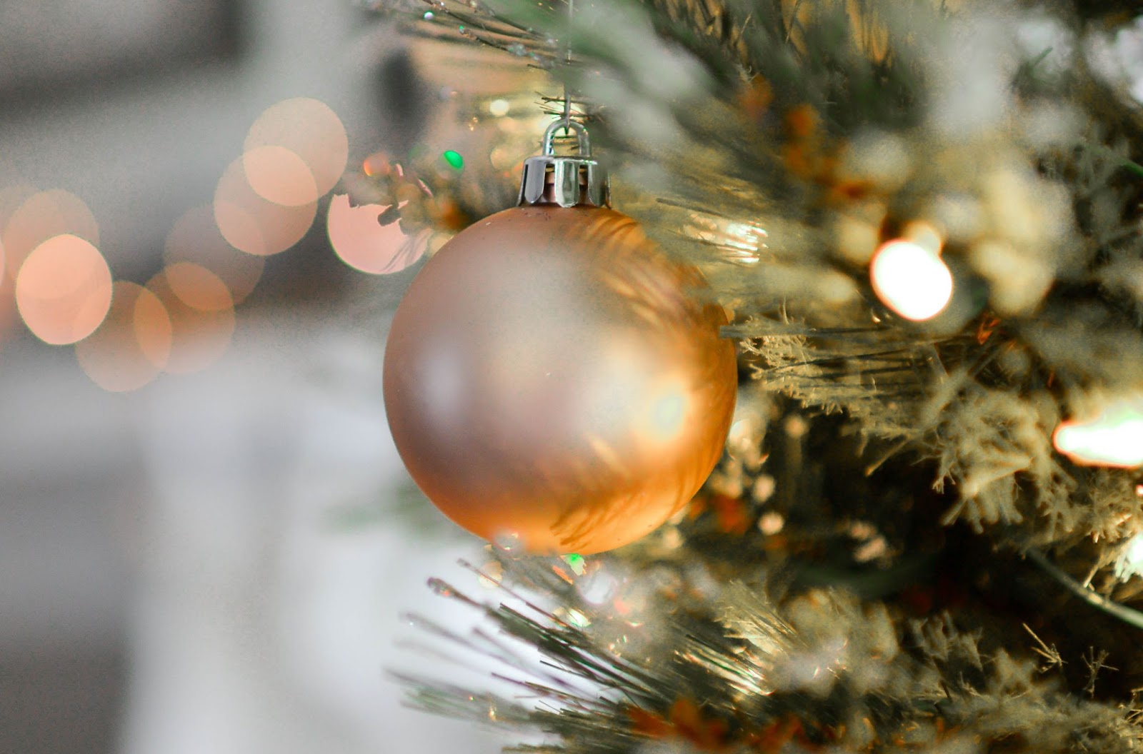 A sparkling gold ornament hanging elegantly on a Christmas tree, adding a touch of shimmer and festivity to the decorations.