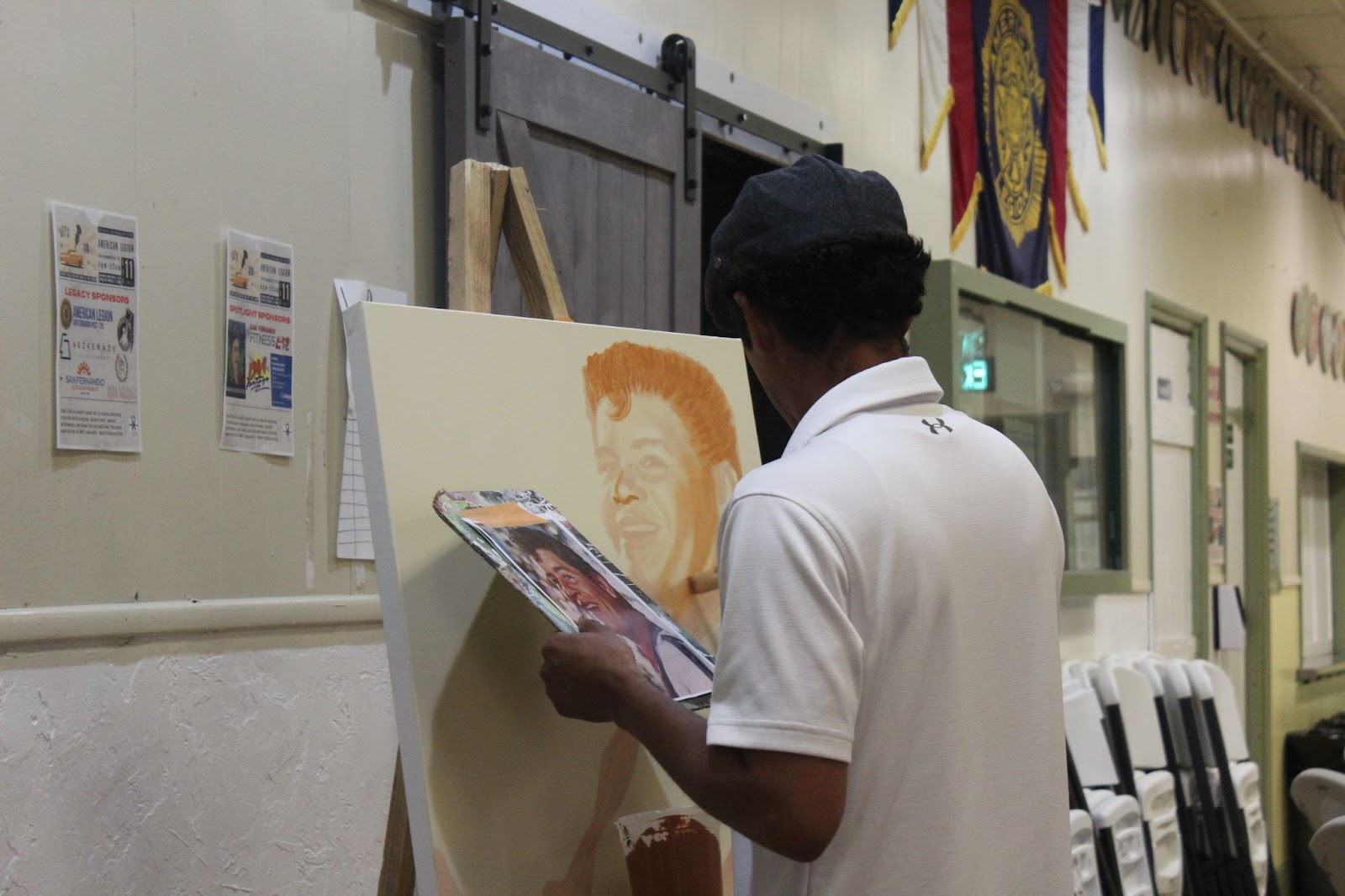 Muralist Levi Ponce painting a portrait of Ritchie Valens at the KROJ benefit concert