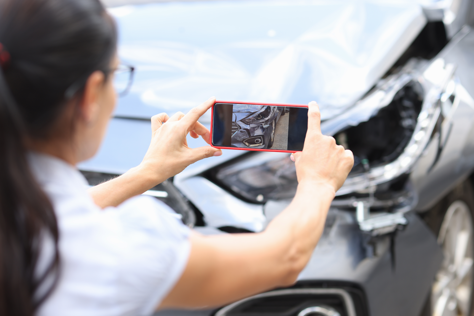 woman taking a picture of an accident scene