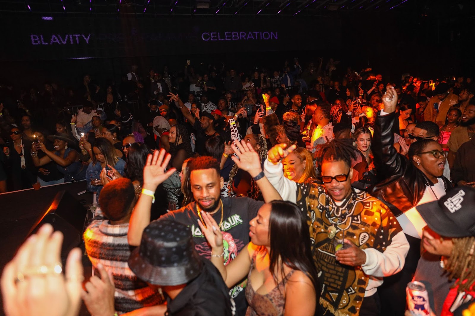 A large crowd of diverse party attendees dancing at Blavity's Music Awards Celebration