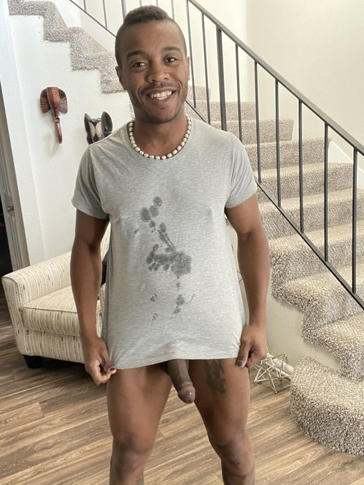 Jake Waters wearing a grey t shirt covered in cum stains wearing no pants and showing off his half erect cut penis