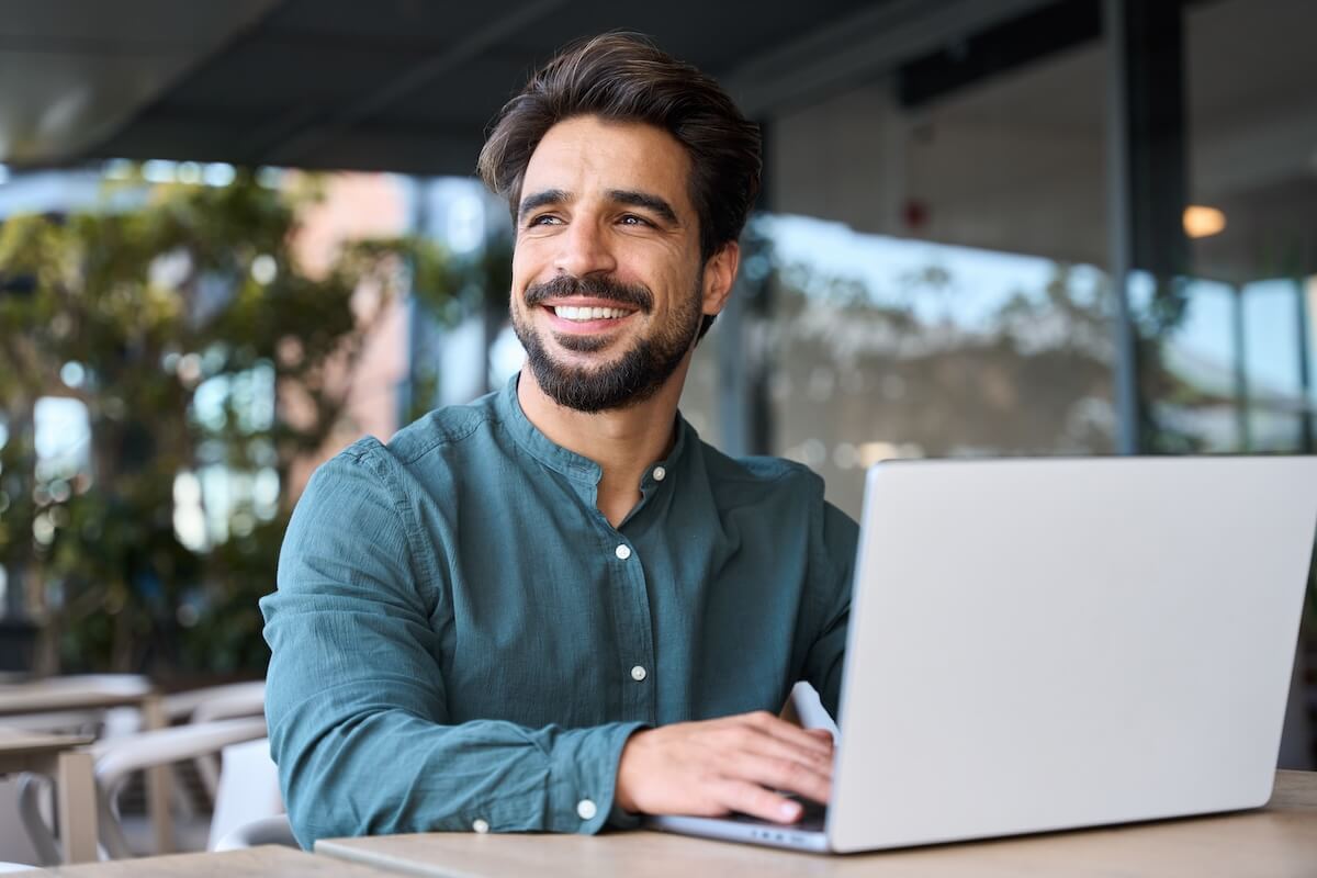 Manager smiling while using a laptop