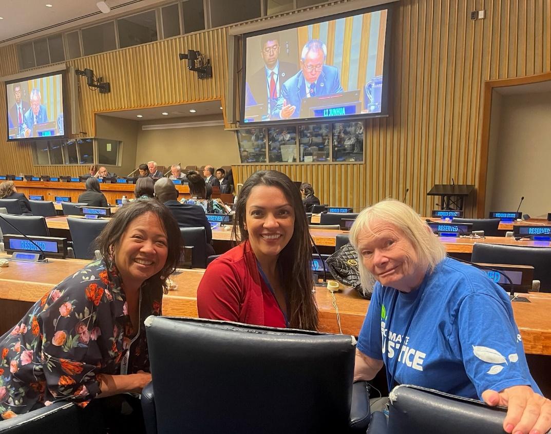 A group of women sitting in chairs in a room with a large screen Description automatically generated