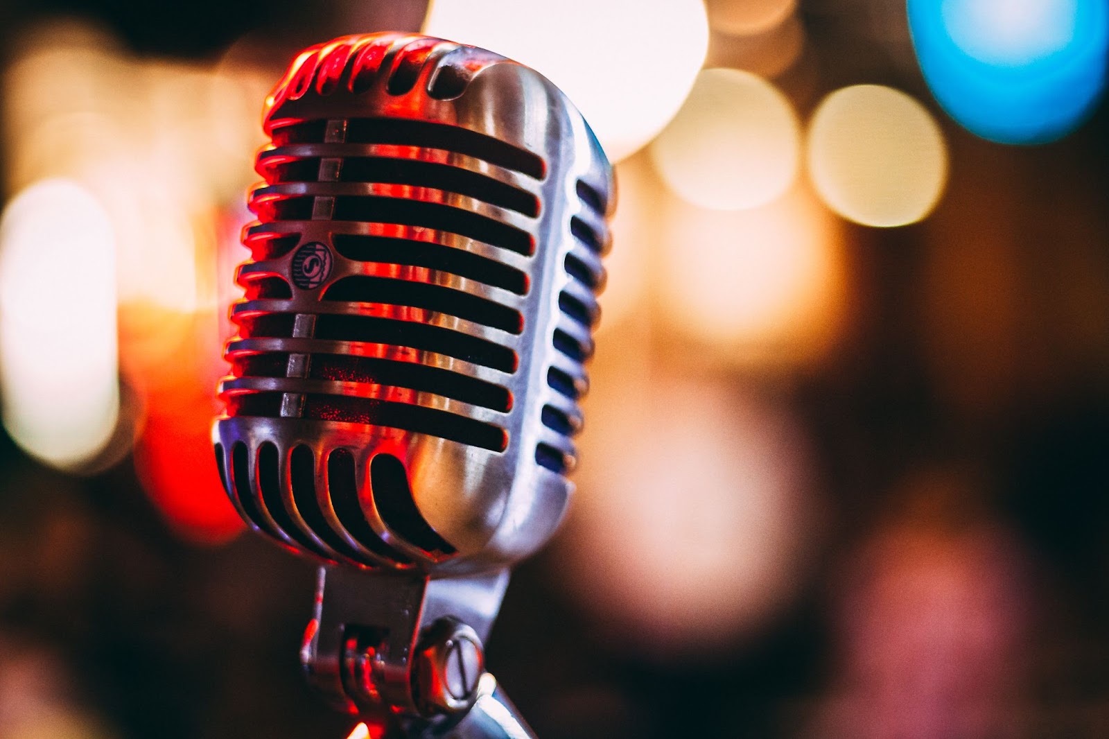 a microphone highlighted with red light with bokeh circles behind it, highlighting Kelowna's live music scene
