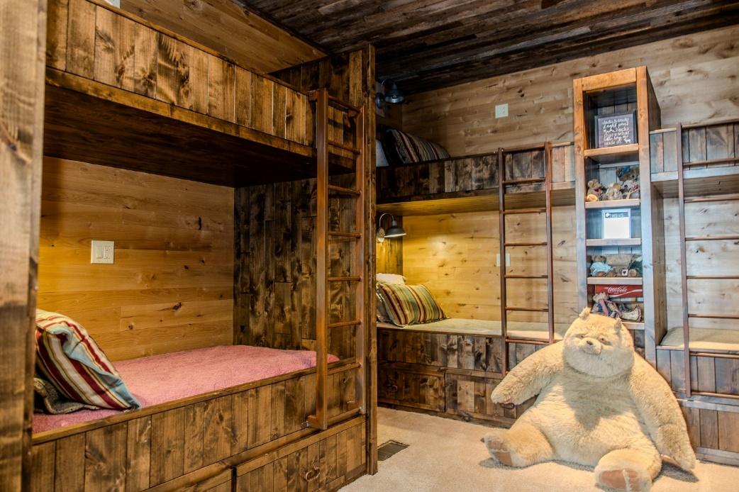 A room with bunk beds and a teddy bear

Description automatically generated