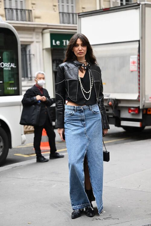 Picture showing a lady rocking the black jacket  with a jean skirt