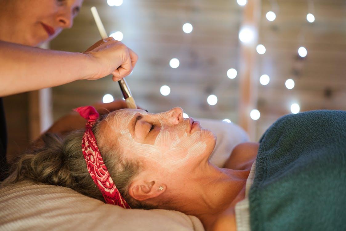 Free Female applying mask on face in spa Stock Photo