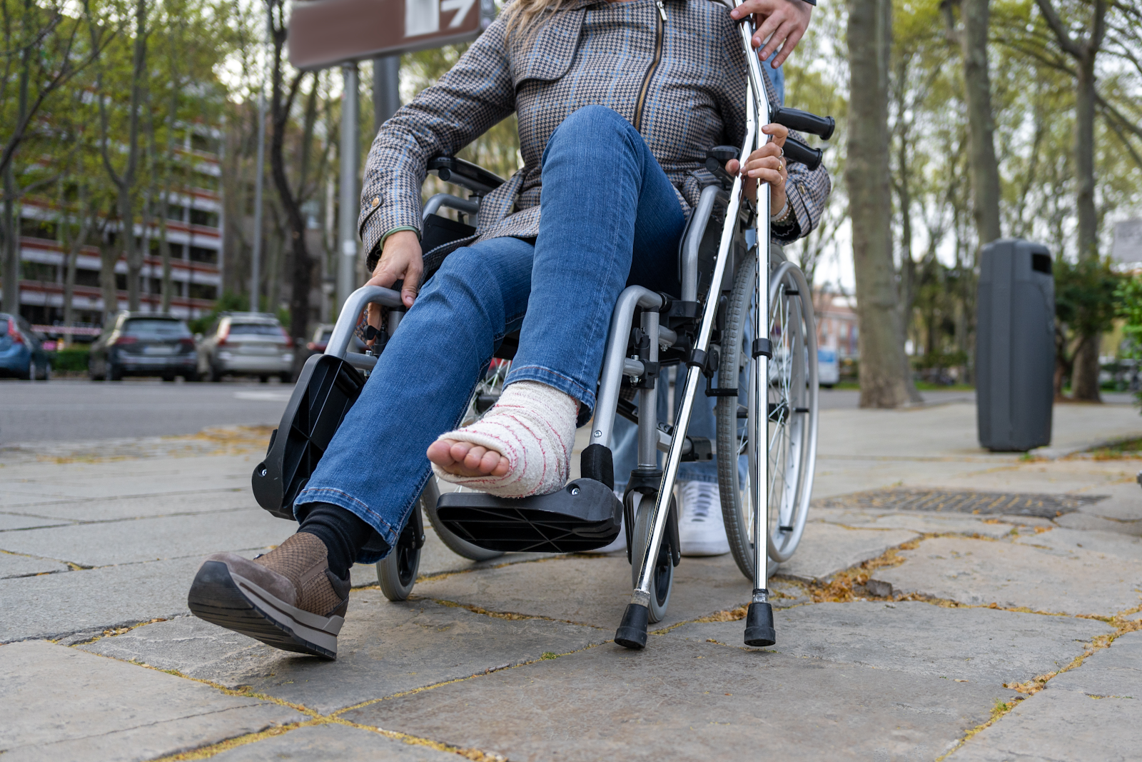 woman in a wheelchair with crutches and a brace on, she went to civil court and federal court for a personal injury claim