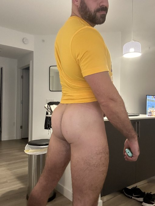 Max Romano wearing a yellow t shirt and no pants showing off his thick legs and naked ass cheeks for his gay xxx onlyfans subscribers