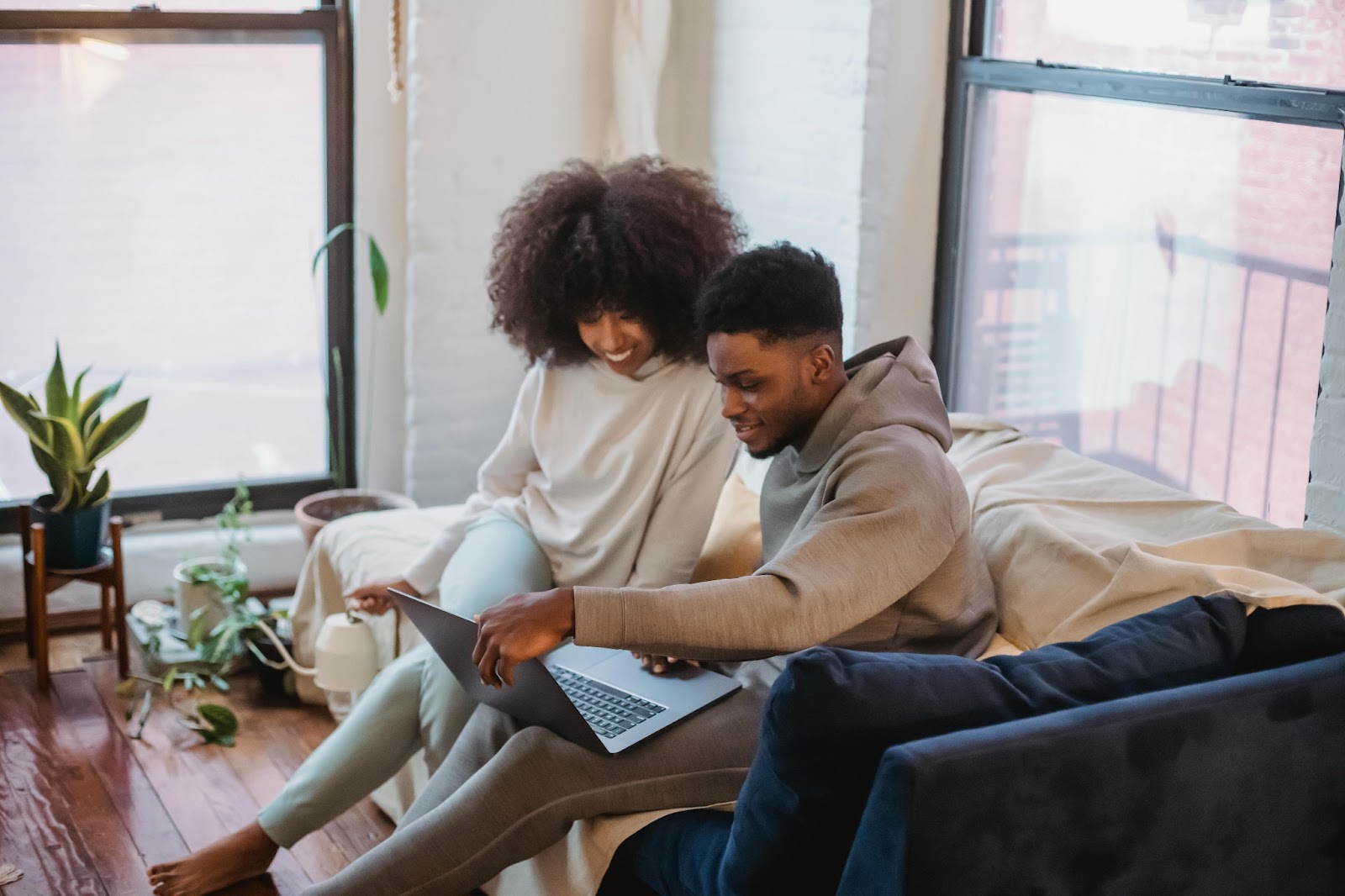 A future bride and groom getting destination wedding ideas and planning on a laptop from home. 