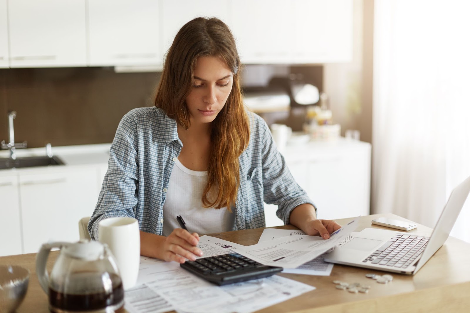 mulher calcula impostos no computador e na calculadora