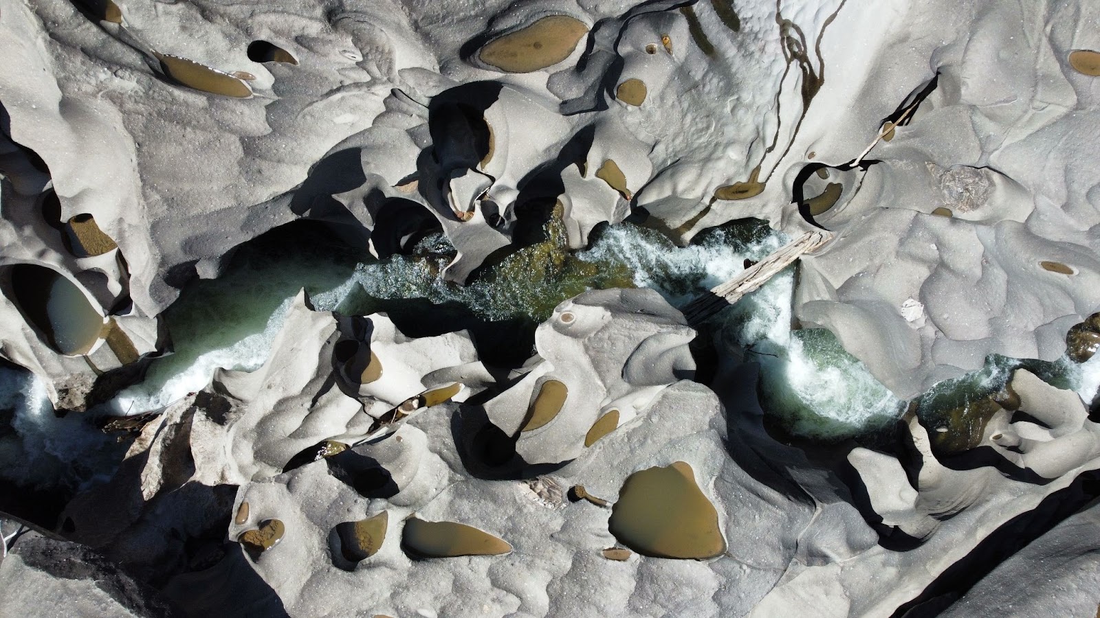Visão aérea do Vale da Lua, na Chapada dos Veadeiros, com as rochas cinzentas e a água correndo por entre as pedras