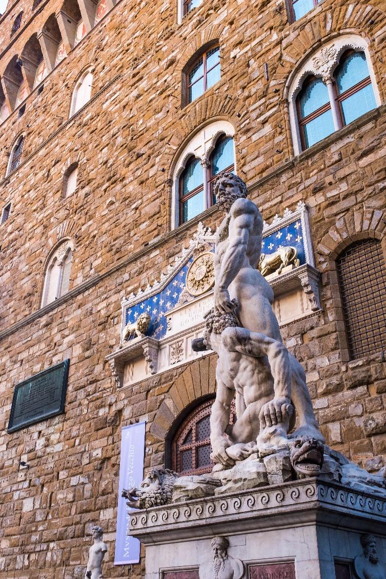 A statue of two people in front of a building

Description automatically generated