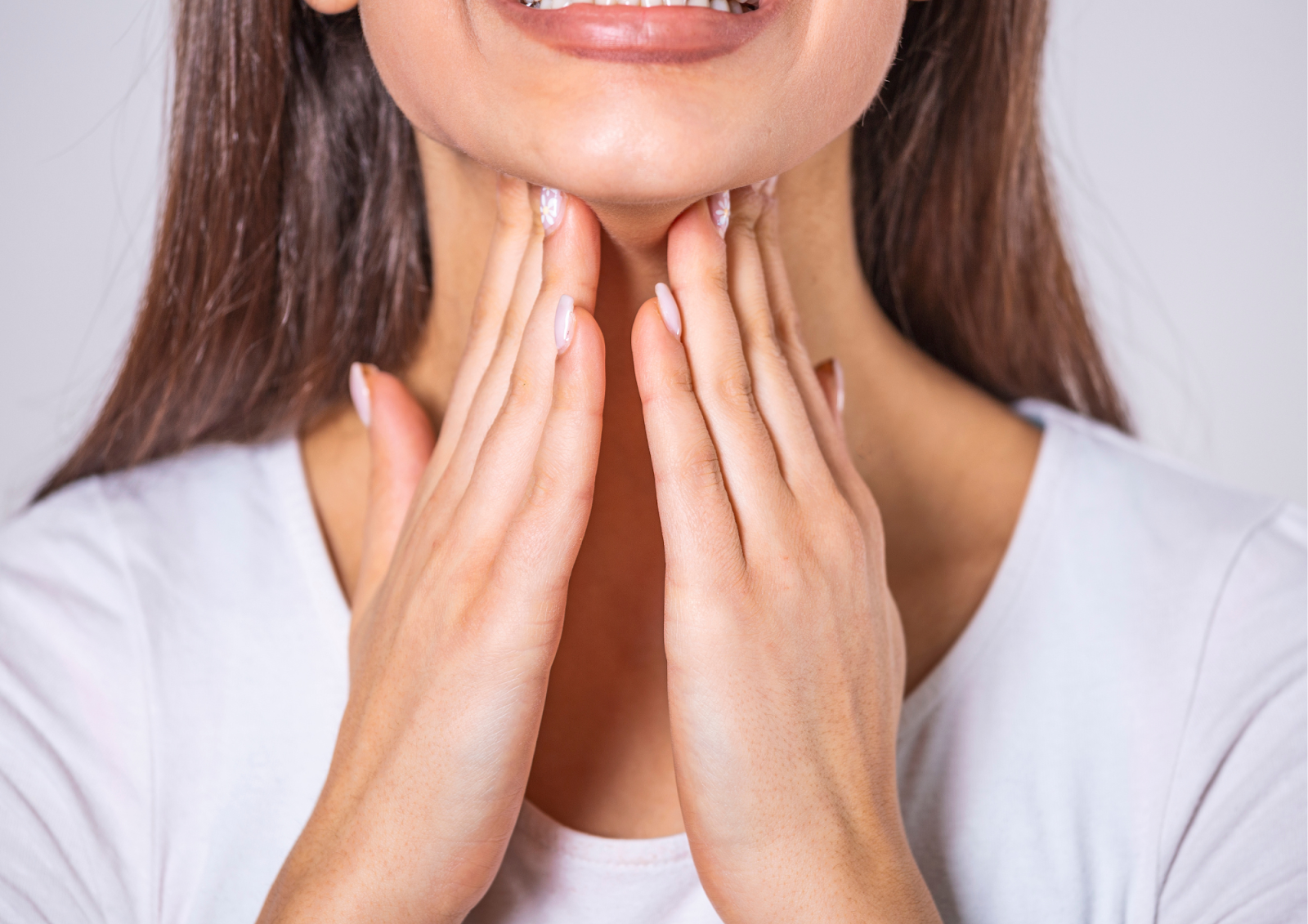 a woman trying to feel any abnormality in her thyroid gland