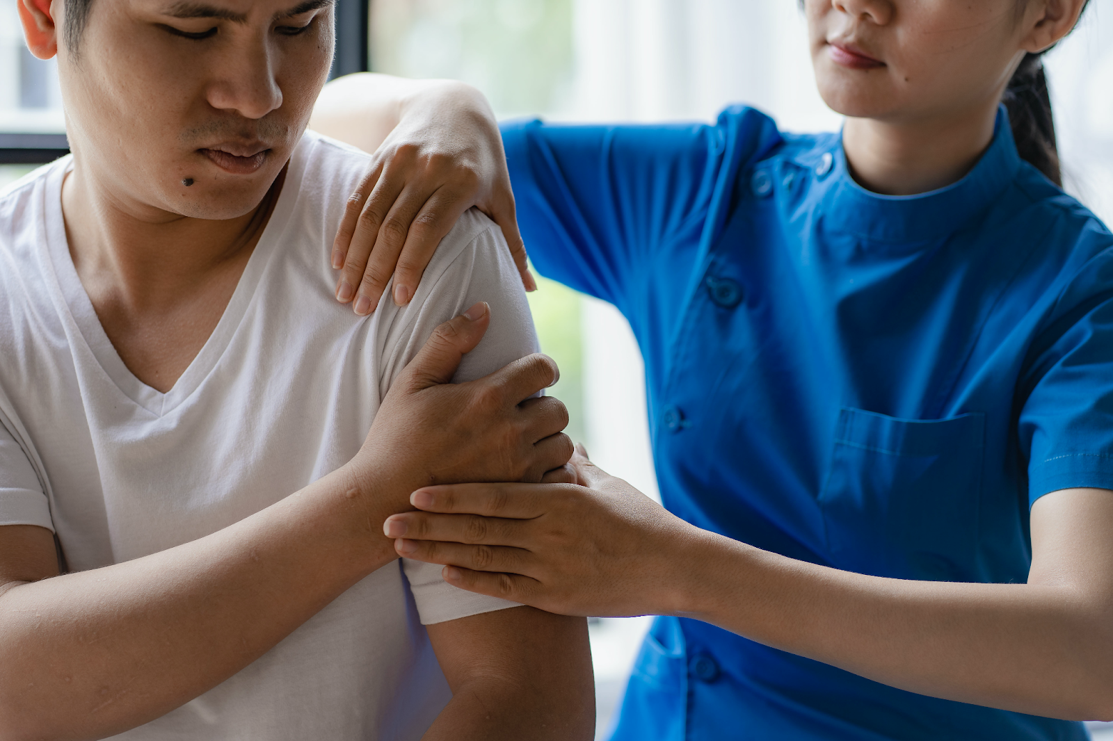 médica realizando um exame clínico em um paciente com fraqueza muscular no braço