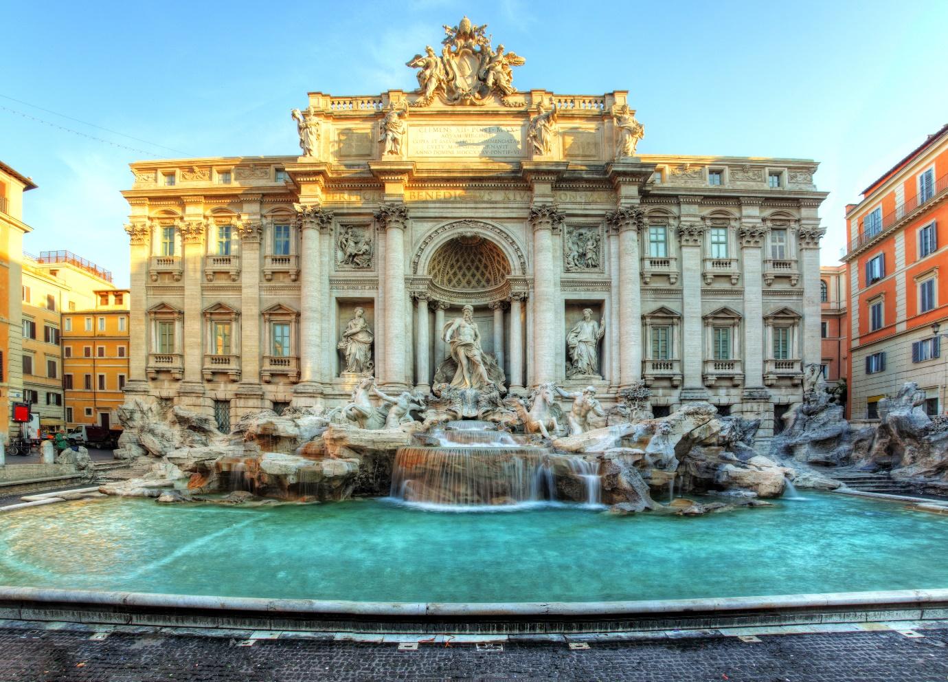 A large stone building with a fountain with Trevi Fountain in the backgroundDescription automatically generated