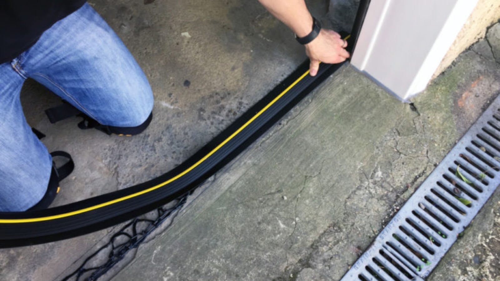 A homeowner installing a threshold seal for the garage door