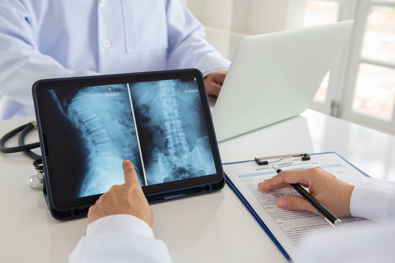doctor pointing at the xray of a spine