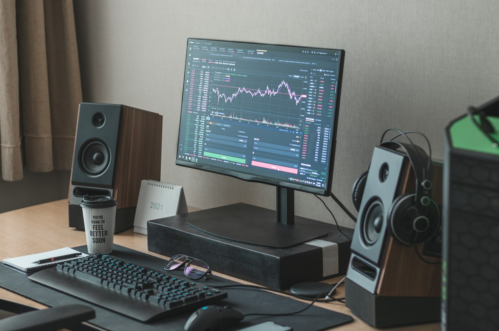 A desktop computer setup with a monitor displaying stock market charts.