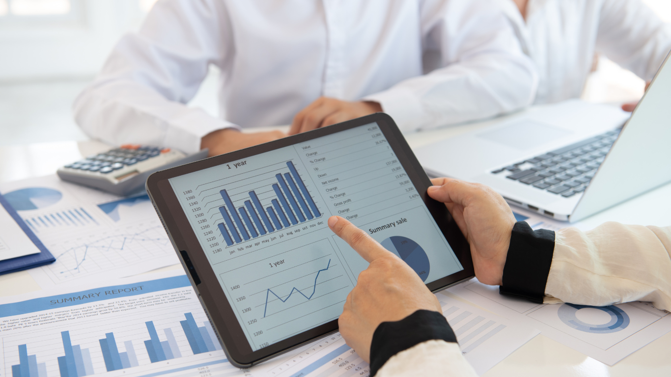 person holding tablet with financial graphs