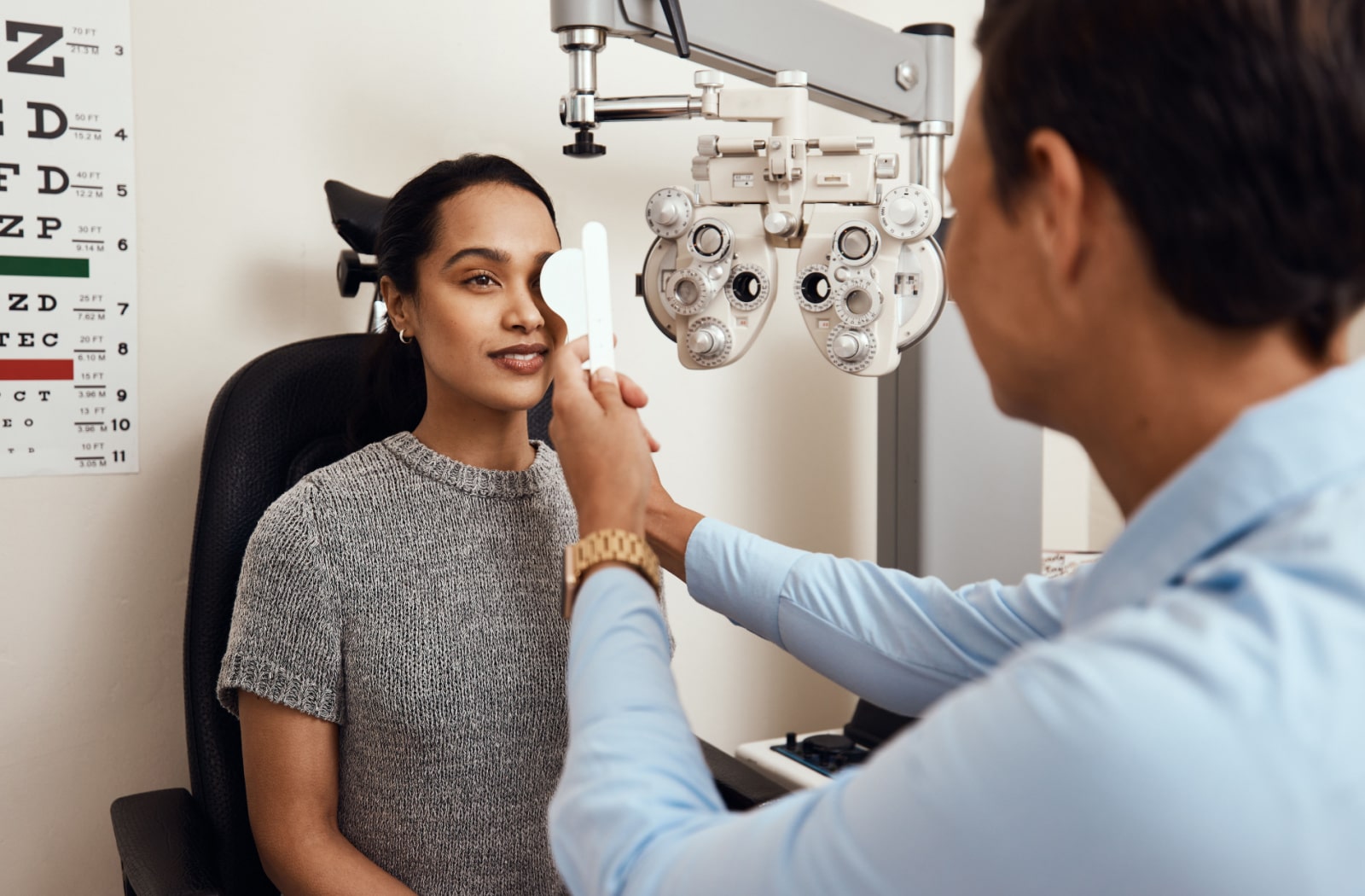 A woman has her eyes examined by an optometrist