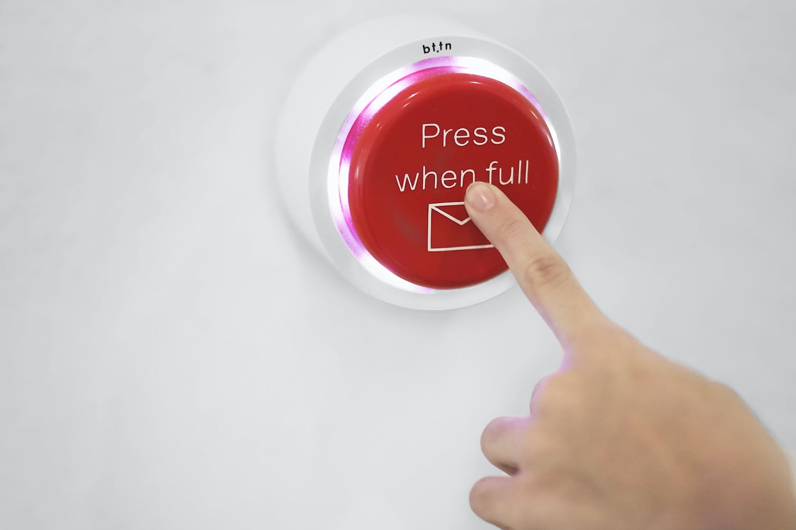 A person pushing a red button that says “Press when full” and includes an email icon.