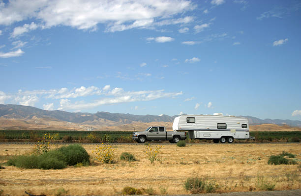 A truck pulls along a motor-home trailer