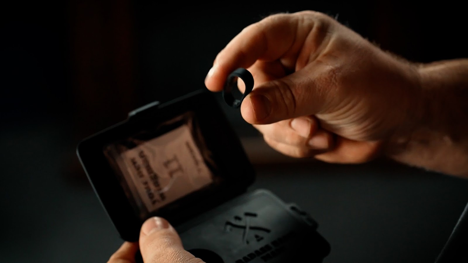 Two fingers squeezing silicone ring showing flexibility