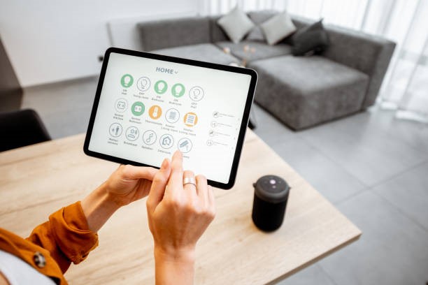 Woman controlling smart devices with a digital tablet at home Young woman controlling home with a digital touch screen panel. Concept of a smart home and mobile application for managing smart devices at home smart lighting system stock pictures, royalty-free photos & images